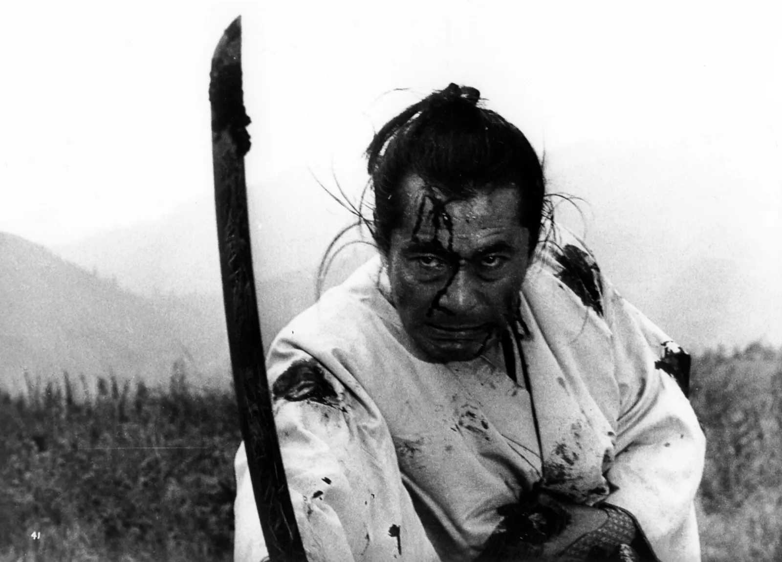 A battered samurai in a torn robe, standing his ground in the hills, in a scene from Akira Kurosawa's Seven Samurai (1954)