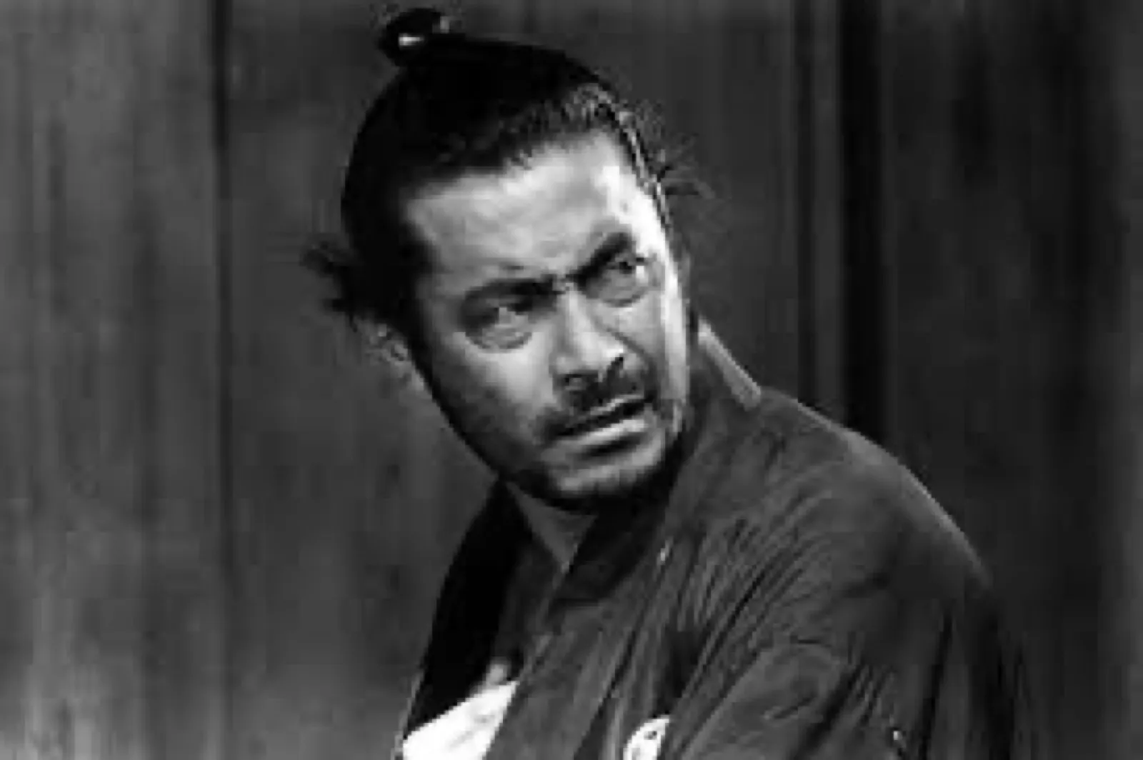 The ronin fixing a hard, skeptical look off-frame, in a scene from Akira Kurosawa's Yojimbo (1961)