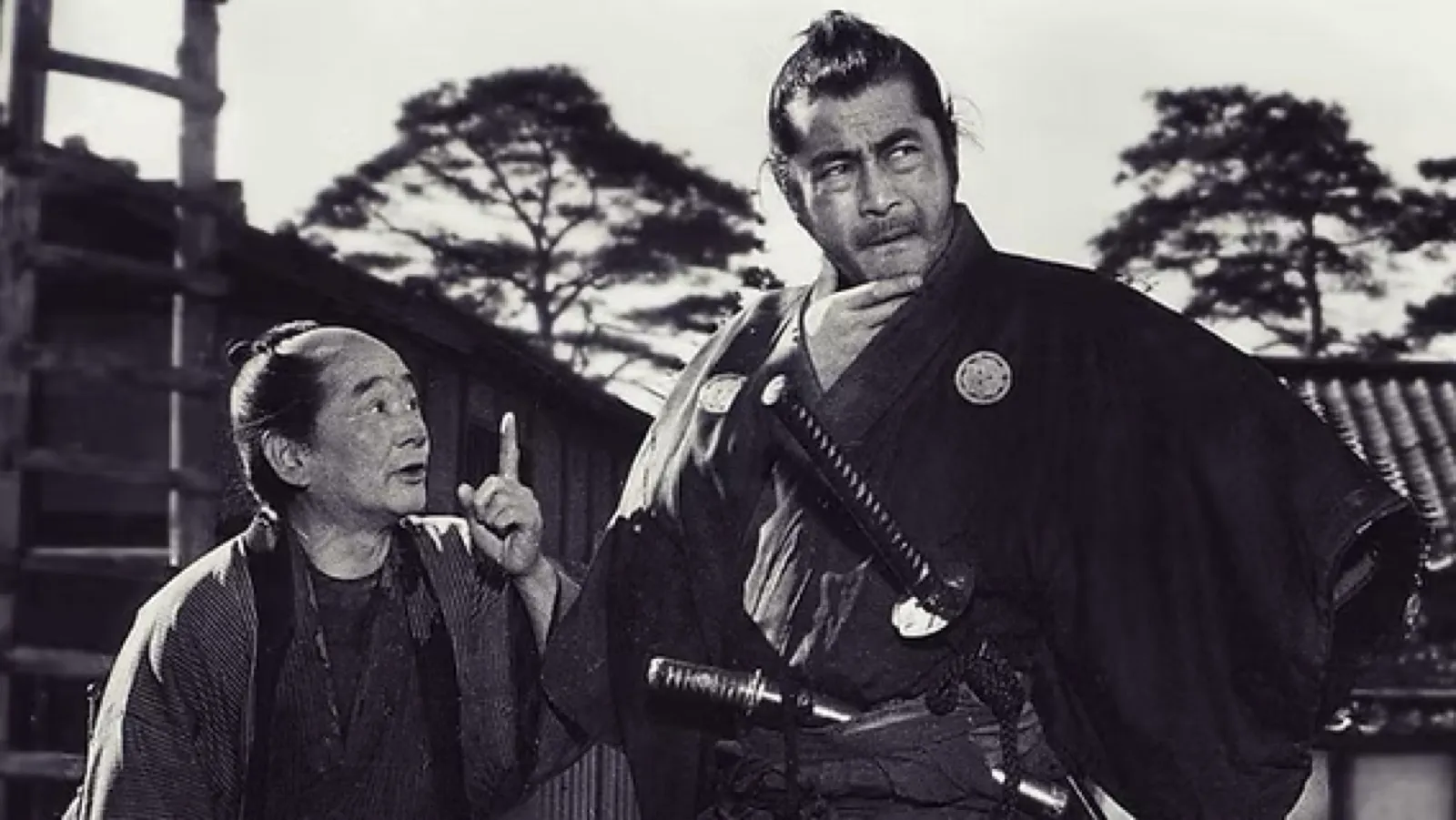 An older retainer raises a finger in counsel beside the ronin, in a scene from Akira Kurosawa's Sanjuro (1962)